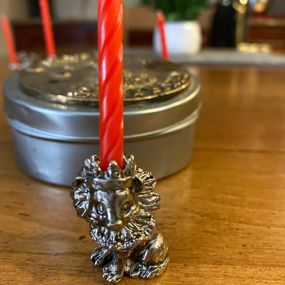 Set of animal candle holders stored in a metal tin.